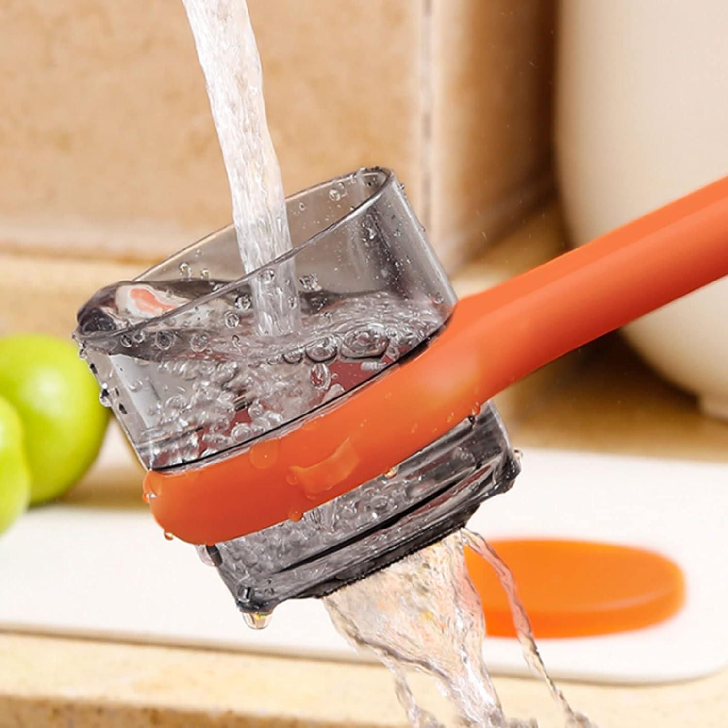 Close-up of a kitchen faucet with water flowing into a glass, with a blurred background.